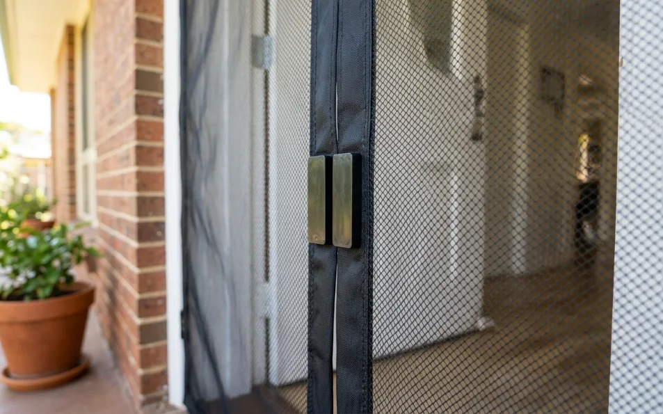Detalle del cierre automático con imanes de una cortina mosquitera para puerta